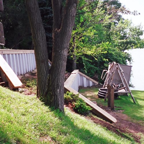 Building and backfilling a two terraced Grey PVC retention wall by hand and wheel barrow! Houses were 6-8' apart on this lake and too steep for heavy equipment!