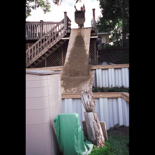 Building and backfilling a two terraced Grey PVC retention wall by hand and wheel barrow! Houses were 6-8' apart on this lake and too steep for heavy equipment!